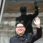 Howard X yang mirip Kim Jong-un melambai ke luar gedung di Hong Kong (7/6). Ketika dunia menunggu pertemuan bersejarah antara Presiden AS Donald Trump dan Kim Jong Un, Howard X akan tampil di Singapura. (AFP Photo/Anthony Wallace)