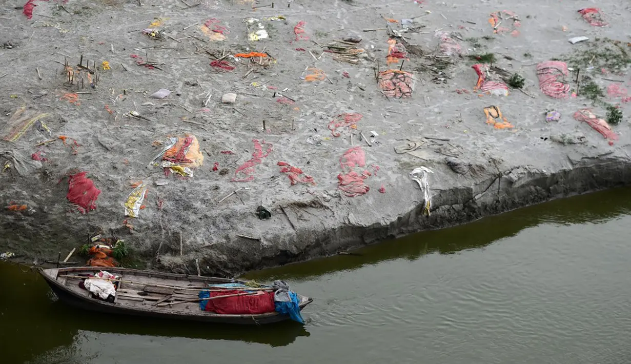 Kuburan dangkal di pasir, beberapa di antaranya diduga orang yang meninggal karena virus corona COVID-19, terlihat dekat tempat kremasi di tepi Sungai Gangga, Phafamau, Allahabad, India, Sabtu (5/6/2021). (SANJAY KANOJIA/AFP)