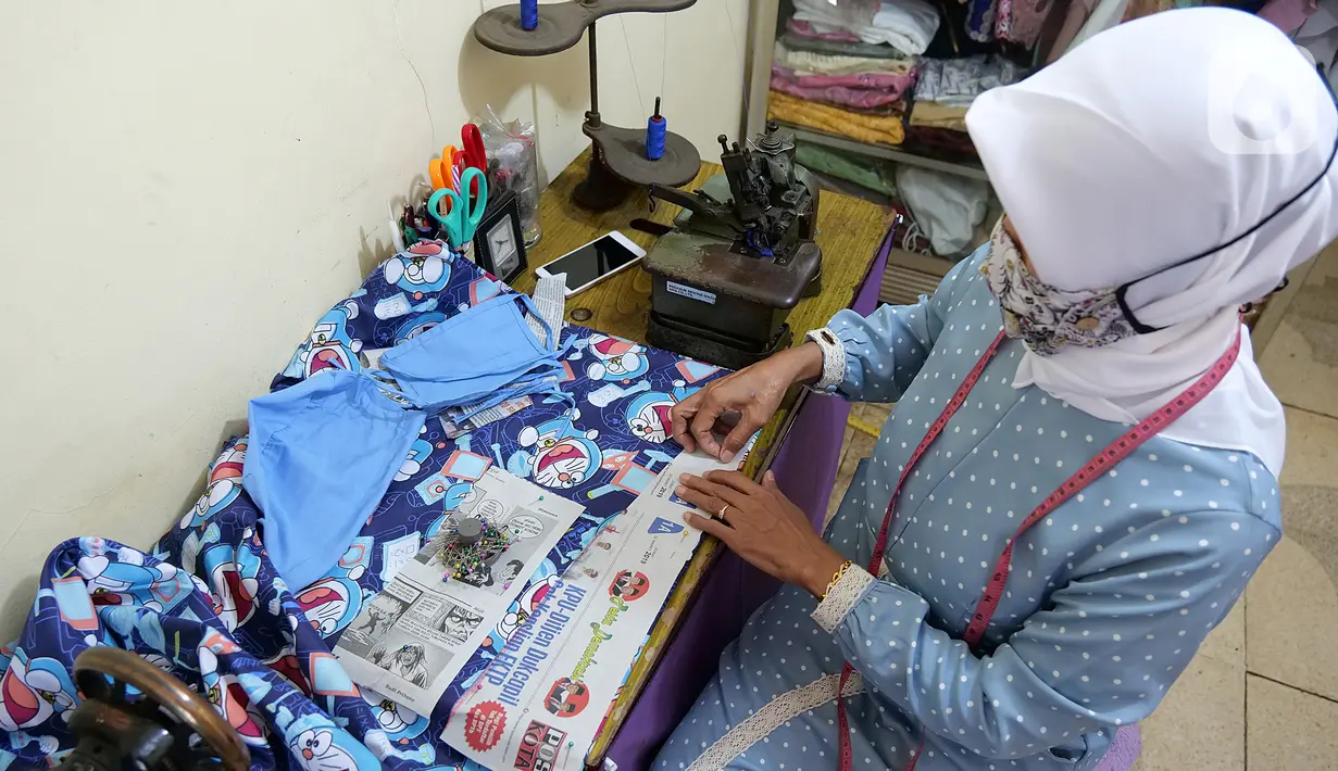 Penjahit sedang membuat pola penutup kepala di kawasan Cipinang Cempedak, Jakarta, Kamis (18/6/2020). Kreasi penutup kepala, masker dan Gown yang di inisiasi oleh seorang dokter di RSIA Tambak yang di design untuk khusus tema anak saat masa Pandemi  COVID-19. (Liputan6.com/Herman Zakharia)