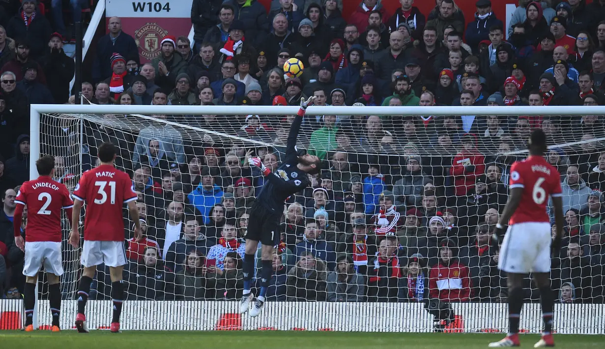 Kiper Manchester United David de Gea berusaha menangkap bola saat menjamu Chelsea pada laga pekan ke-28 Premier League, di Old Trafford, Minggu (25/2). Bermain di hadapan pendukung sendiri, Manchester United menundukan Chelsea 2-1.  (Oli SCARFF / AFP)