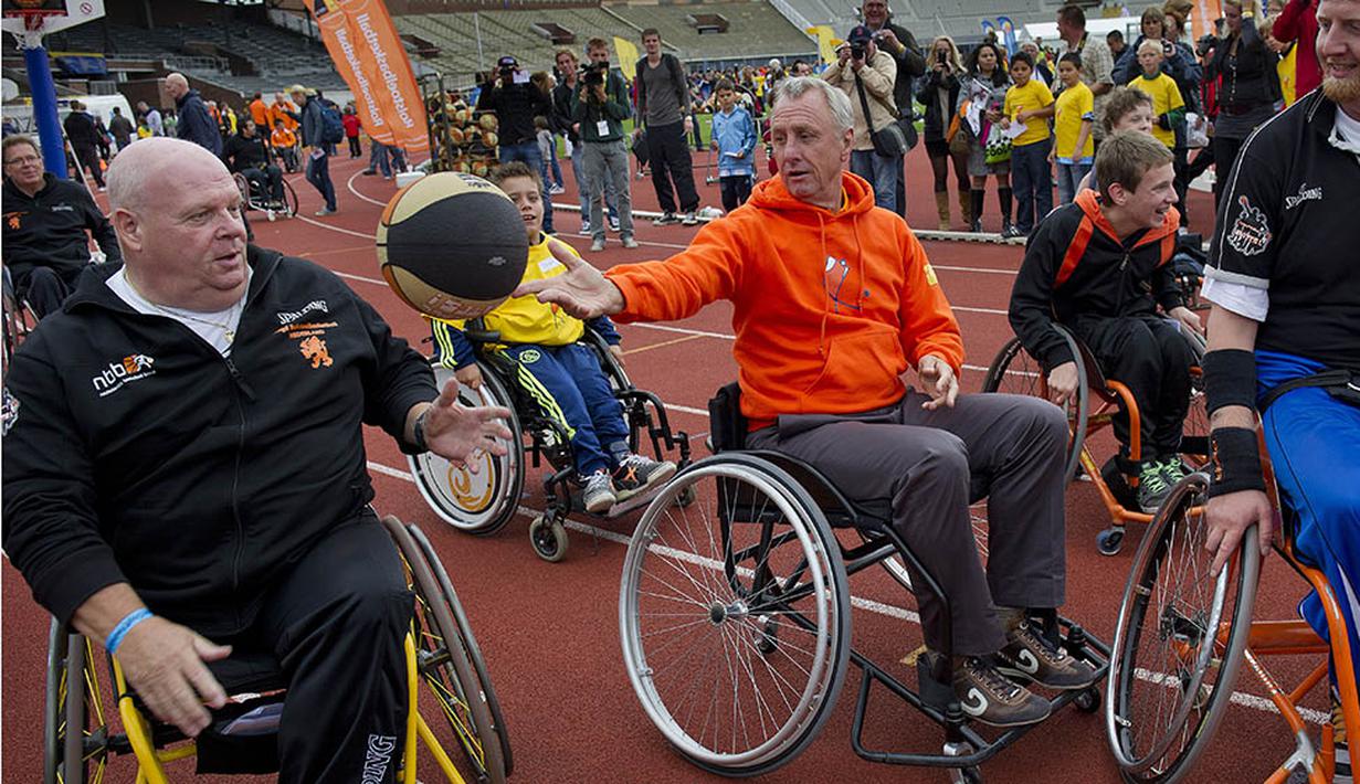Johan Cruyff menaiki kursi roda bersama penyandang disabilitas pada acara Cruyff Foundation di Olympic Stadion, Amsterdam,  Rabu (14/9/2011). Legenda sepak bola itu merupakan sosok yang sangat peduli terhadap kaum disabilitas. (AFP/Marcel Antonisse)