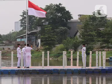 Anggota Paskibraka melakukan pengibaran bendera merah putih di Sungai Cisadane, Kota Tangerang, Banten, Kamis (28/10/2021). Pengibaran bendera merah putih yang di ikuti puluhan pemuda tersebut di lakukan untuk memperingati hari sumpah pemuda. (Liputan6.com/Angga Yuniar)