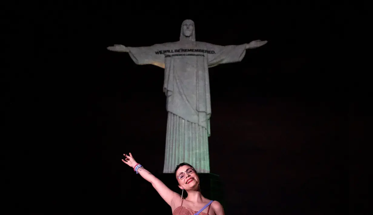 <p>Seorang penggemar berpose di depan gambar Kristus Sang Penebus untuk menyambut penyanyi AS Taylor Swift di Rio de Janeiro, Brasil, pada 16 November 2023. (Florian Plaucher / AFP)</p>