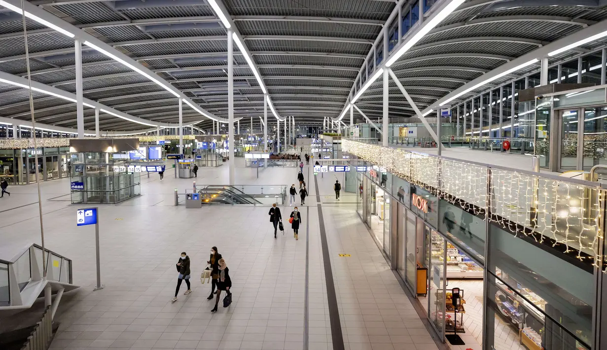 Orang-orang berjalan pada hari pertama pemberlakukan lockdown ketat untuk meredam COVID-19 di Stasiun Pusat Utrecht, Selasa (15/12/2020). Semua tempat bisnis di Belanda kecuali yang menjual kebutuhan pokok harus tutup saat pemerintah Belanda menetapkan lockdown total. (ROBIN VAN LONKHUIJSEN/AN /AFP)