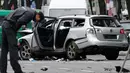 Petugas kepolisian memeriksa bangkai mobil Volkswagen yang rusak di Berlin , Jerman, (15/3). Warga Jerman di gegerkan oleh sebuah mobil yang tiba meledak di pusat kota Berlin. (REUTERS / Fabrizio Bensch)