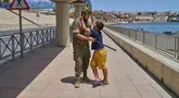 Seorang anak berusia 12 tahun yang menyeberang ke Spanyol tanpa didampingi orang dewasa dikawal oleh seorang tentara Spanyol ke perbatasan Spanyol-Maroko sementara anak itu memohon agar tidak dikirim kembali ke Maroko dari wilayah kantong Spanyol di Ceuta, Senin, 3 Agustus 2026. (Foto AP/Bernat Armangue)