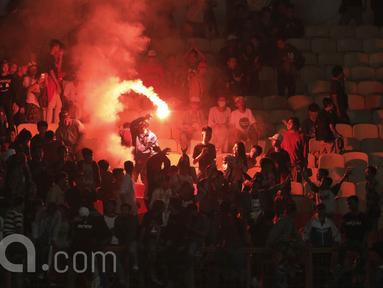 Suporter menyalakan flare saat memberikan dukungan kepada pemain Timnas Indonesia U-16 saat pertandingan melawan Singapura pada laga uji coba di Stadion Wibawa Mukti, Cikarang, Kamis, (8/6/2017). Indonesia menang 4-0. (Bola.com/M Iqbal Ichsan)