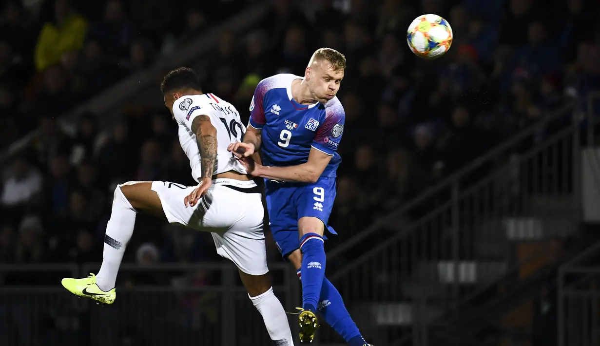 Gelandang Prancis, Corentin Tolisso, duel udara dengan striker Islandia, Kolbeinn Sigthorsson, pada laga Kualifikasi Piala Eropa 2020 di Reykjavik, Sabtu (11/10). Islandia kalah 0-1 dari Prancis. (AFP/Jonathan Nackstrand)