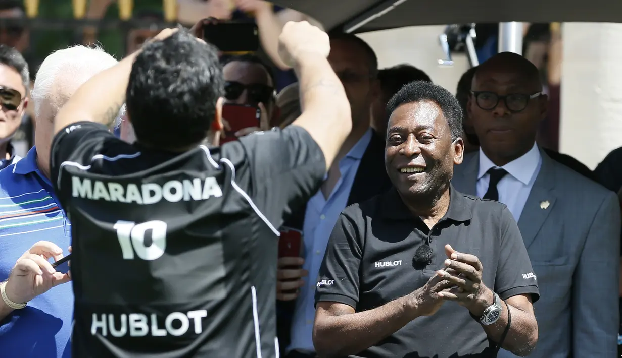 Pele menyambut Maradona setelah mencetak gol dalam laga sepak bola persahabatan yang diadakan oleh Hublot di Jardin du Palais Royal, Paris, jelang Piala Eropa 2016, (9/6/2016). (AFP/Patrick Kovarik)