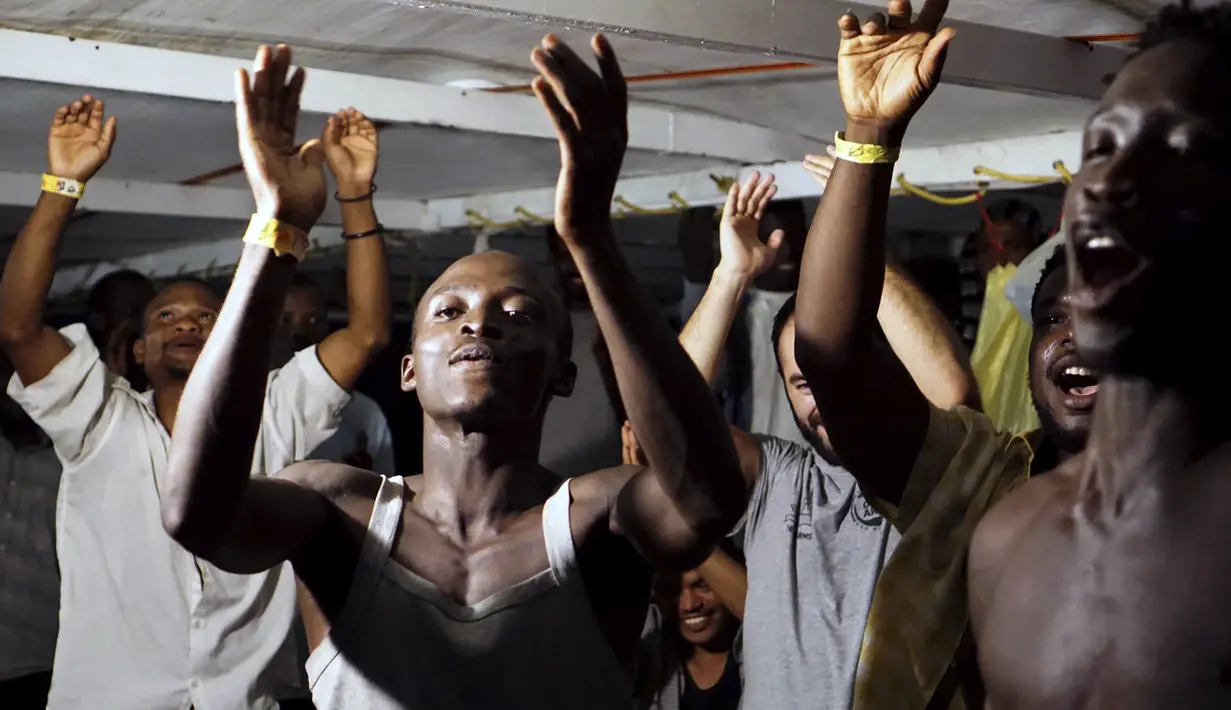 Para imigran di atas kapal Open Arms merayakan berita tentang seorang jaksa penuntut Italia yang telah memerintahkan bahwa para migran akan turun di pulau Lampedusa, Italia selatan (20/8/2019). Setidaknya 15 migran lainnya melompat ke laut dari kapal Open Arms untuk menuju pantai Italia. (AP Photo/F