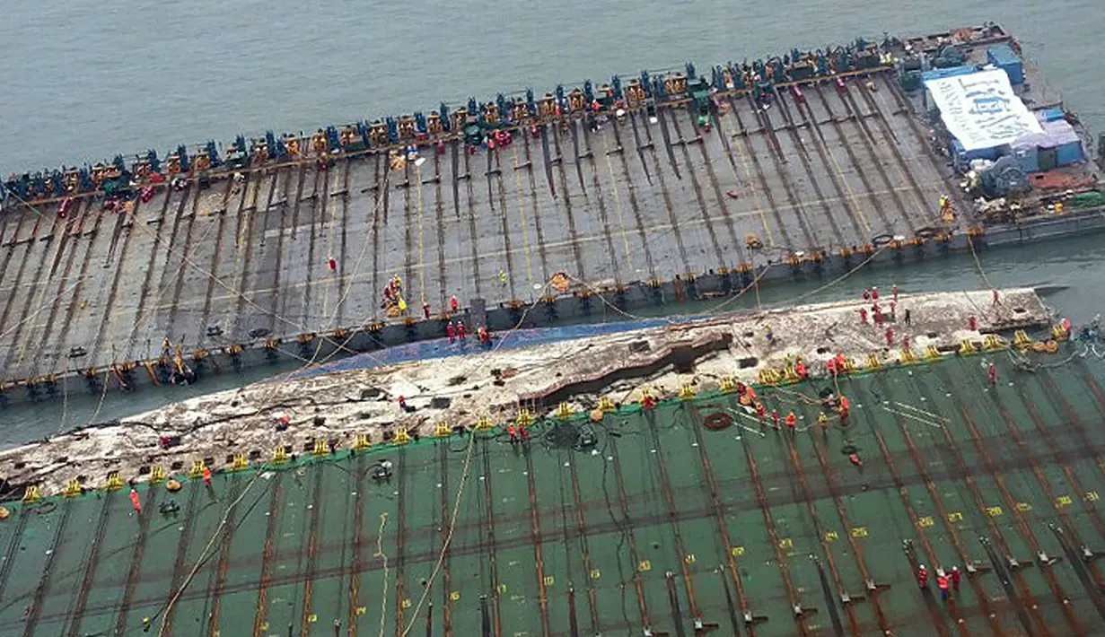 Bangkai kapal feri Sewol yang tenggelam hampir tiga tahun lalu dan menewaskan 304 orang, muncul ke permukaan, di pulau barat daya Jindo, Korea Selatan, Kamis (23/3). Upaya pengangkatan telah berlangsung sejak Rabu kemarin. (Park Gyung-woo/Hankookilbo/AP)