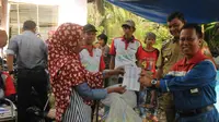 General Manager RU III PT Pertamina Sumbagsel Djoko Priyono menyerahkan buku tabungan nasabah Bank Sampah Patratura ke salah satu warga Palembang (Liputan6.com / Nefri Inge)