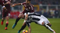 Gelandang Juventus, Stefano Sturaro, terjatuh saat berusaha melewati bek Torino, Luca Rossettini dalam laga pekan ke-16 Serie A 2016-2017 di Stadion Olimpico Grande Torino, Minggu (11/12/2016). (AFP/Marco Bertorello)