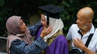 Ilustrasi wisuda, memeluk orang tua. (Photo by Solehuddin Din: https://www.pexels.com/photo/parents-greeting-daughter-university-graduate-10460163/)