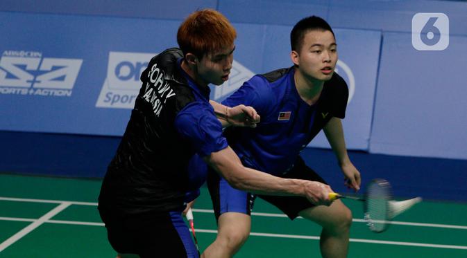Ganda putra Malaysia, Aaron Chia / Soh Wooi Yik, mengembalikan kok saat melawan Fajar Alfian/Muhammad Rian Ardianto pada final bulutangkis beregu putra SEA Games 2019 di Multinlupa Sport Center, Rabu (4/12/2019). Fajar / Rian kalah 17-21 dan 13-21. (Bola.com/M Iqbal Ichsan)