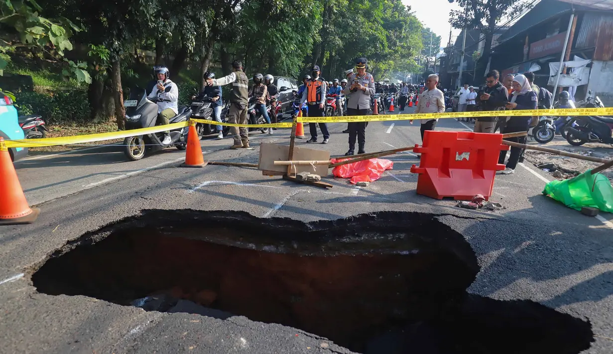 Pengendara melintas di sisi ruas jalan yang ditutup sebagian akibat amblas di Jalan Raya Lenteng Agung, Jakarta Selatan, Jumat (29/5/2026). (merdeka.com/Arie Basuki)