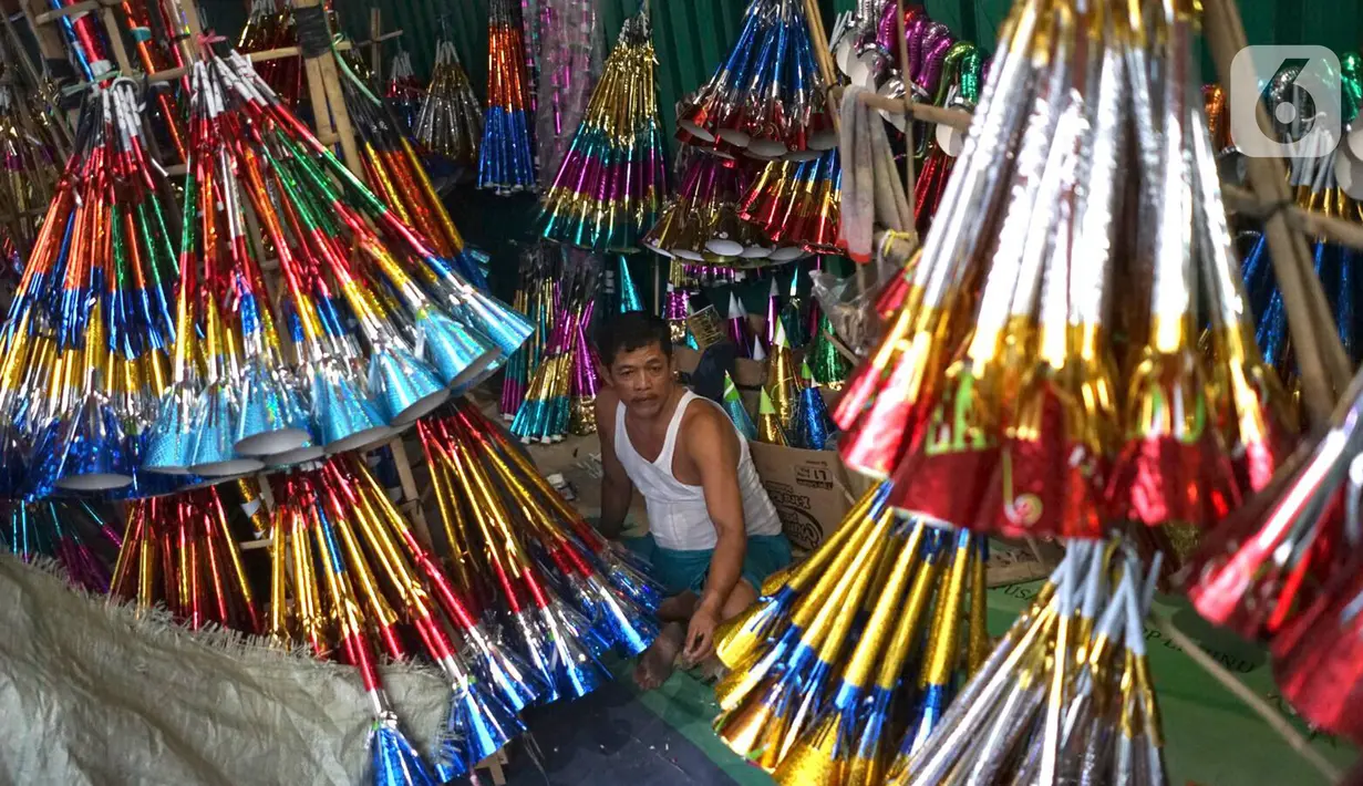 Pedagang terompet menunggu calon pembeli di kawasan Glodok, Jakarta, Jumat (27/12/2019). Menjelang perayaan Tahun Baru 2020, penjual terompet musiman mulai marak di sejumah kawasan dengan harga jual berkisar Rp5ribu hingga Rp15ribu tergantung model. (Liputan6.com/Immanuel Antonius)