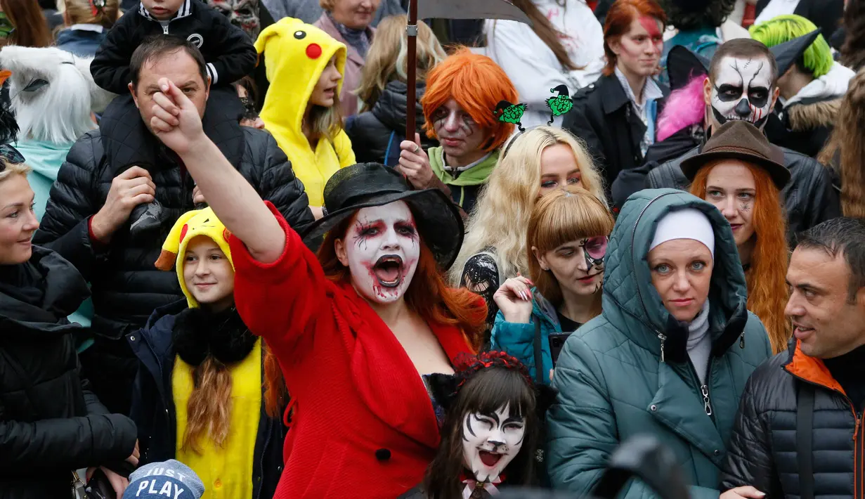 Orang-orang mengenakan kostum dan dandanan menyerupai zombie ketika berpartisipasi dalam 'Zombie Walk' di pusat Kota Kiev, Ukraina, 26 Oktober 2019. Menjelang perayaan Halloween pada 31 Oktober mendatang, warga di beberapa belahan dunia sudah mulai melakukan acara bertema horor. (AP/Efrem Lukatsky)
