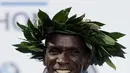 Pelari Kenya, Eliud Kipchoge menunjukkan medali emasnya saat memenangkan Berlin Marathon ke-45 di Berlin, Jerman, Minggu (16/9). Berlin Marathon menjadi ajang lari marathon kesembilan yang ia menangkan secara beruntun. (AP Photo/Markus Schreiber)