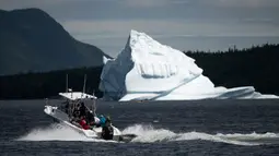 Kapal pariwisata menuju gunung es terapung di King's Point, Newfoundland, Kanada, 5 Juli 2019. Wisata gunung es terapung menyumbang hampir 570 juta dolar Kanada atau sekitar 389 juta euro untuk ekonomi lokal. (Johannes Eisele/AFP)
