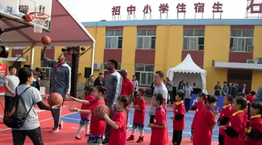 Pemain New Orleans Pelicans memberikan pelatihan kepada para siswa setalah NBA Cares Learn and Play Center di Sekolah Migran Huangzhuang, Beijing, Tiongkok (11/10). Mereka datang ke Tiongkok dalam rangka NBA Global Games. (AP Photo/Ng Han Guan)