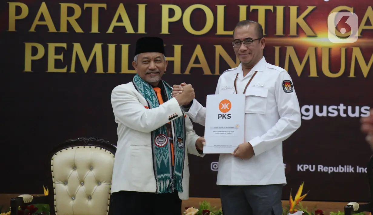 Ketua KPU RI Hasyim Asy'ari menerima berkas dari Presiden PKS Ahmad Syaikhu di Gedung Komisi Pemilihan Umum (KPU) RI, Jakarta, Senin (1/8/2022). Pendaftaran calon partai politik (parpol) peserta Pemilu dimulai tanggal 1 hingga 14 Agustus 2022. Pada hari pertama partai yang mendaftar yakni PDIP, PKS, PKP, Partai Reformasi, Partai Nasdem, Partai Prima, Perindo, dan PBB. (Liputan6.com/Angga Yuniar)