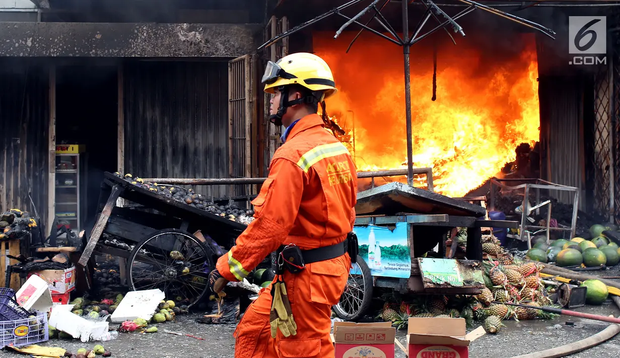 Petugas pemadam kebakaran melintas di depan ruko yang terbakar di Pasar Kebayoran Lama, Jakarta, Selasa (13/6). Kebakaran yang melanda ruko tersebut belum diketahui penyebabnya. (Liputan6.com/Johan Tallo)