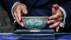 Wakil Kepala Sotheby Asia, Nicolas Chow memegang mangkuk langka dari masa Dinasti Qing pada pratinjau media di Hong Kong, Selasa (3/4). Mangkuk antik kepunyaan Kaisar Kangxi itu terjual dengan harga USD 30,4 juta (Rp 417 miliar). (ISAAC LAWRENCE/AFP)