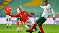 Bek Bulgaria, Kamen Hadzhiev, berusaha melewati gelandang Inggris, Jordan Henderson, pada laga Kualifikasi Piala Dunia 2020 di Stadion Vasil Levski, Sofia, Senin (14/10). Bulgaria kalah 0-6 dari Inggris. (AFP/Nikolay Dychinov)