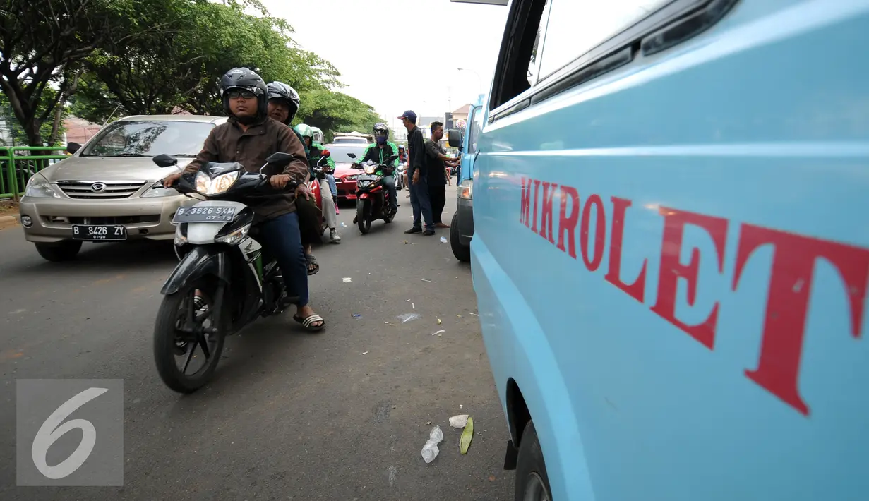 Pengemudi motor melintas di samping mikrolet M 44 yang berderet menutupi persimpangan jalan layang KH Abdulah Syafei, Jakarta, Rabu (25/5). Aksi ini sempat membuat kemacetan panjang menuju Kampung Melayu. (Liputan6.com/Helmi Fithriansyah)