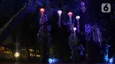 Warga saat memotret Jakarta Lights Festival di Taman Sumenep, Jakarta, Jumat (23/12/2022). Pemprov DKI Jakarta menggelar acara Jakarta Lights Festival sebagai rangkaian perayaan Natal dan Tahun Baru (Nataru) 2023. (Liputan6.com/Herman Zakharia)
