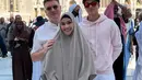 Maudy mengenakan abaya abu-abu senada dengan kerudung khimarnya dan ciput hitamnya. Eddy mengenakan hoodie pink dipadukan celana putih panjang. [@maudykoesnaedi]