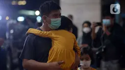 Ekspresi seorang pria yang menggendong anak kecil saat berada di Posko Crisis Center Sriwijaya Air SJ 182, Bandara Soekarno-Hatta, Tangerang, Banten, Sabtu (9/1/2021). Keluarga korban masih menunggu kabar terkait hilang kontaknya pesawat Sriwijaya Air SJ 182. (merdeka.com/Imam Buhori)