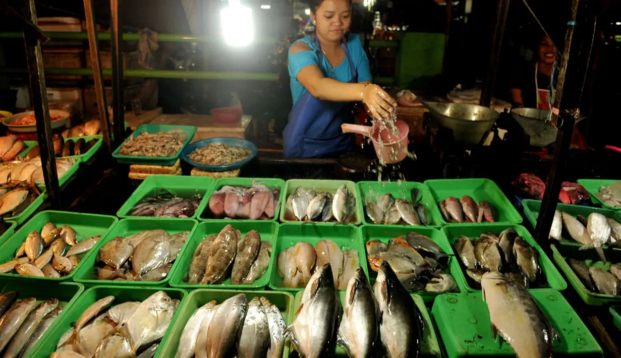Malam menjelang, para pedagang ikan mulai menggelar dagangannya di sepanjang tepi jalan Raya Bogor, Kramatjati, Jakarta Timur (12/5/2014). (Liputan6.com/Johan Tallo)