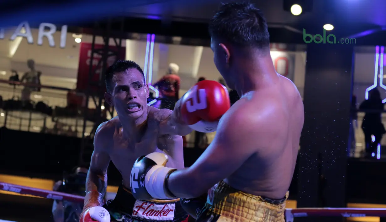 Ilham Leoisa (kiri) berusaha memukul lawannya  asal Thailand, Paiboon Lorkham pada kelas Super-Lightweight Mahkota Boxing Super Series di Cilandak Town Square, Jakarta (10/3/2018). Ilham menang angka mutlak. (Bola.com/Nick Hanoatubun)
