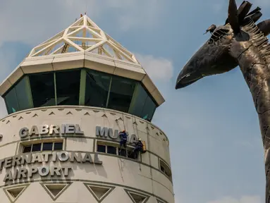 Pekerja memasang plang nama Bandara Robert Mugabe yang baru berganti nama, di Harare, Kamis (9/11). Pemerintah Zimbabwe mengganti nama bandara mereka yang semula bernama Bandara Harare menjadi Bandara Robert Mugabe.  (Jekesai NJIKIZANA/AFP)