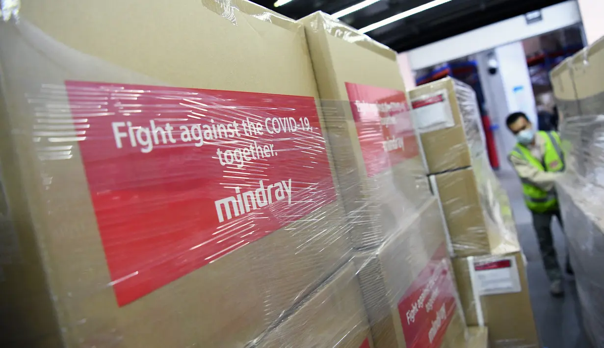 Seorang karyawan mengangkut paket-paket berisi ventilator yang akan diekspor ke Italia di Pusat Manufaktur Guangming milik Mindray Bio-Medical Electronics Co., Ltd. di Shenzhen, Provinsi Guangdong, China selatan, (31/3/2020). (Xinhua/Liang Xu)