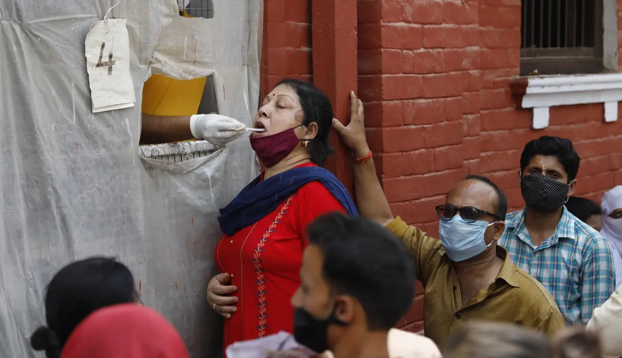 Seorang petugas kesehatan mengambil sampel usap untuk menguji COVID-19 di Prayagraj, India, Rabu (7/4/2021). India mencapai puncak baru dengan 115.736 kasus COVID-19 dalam 24 jam. (AP Photo/Rajesh Kumar Singh)