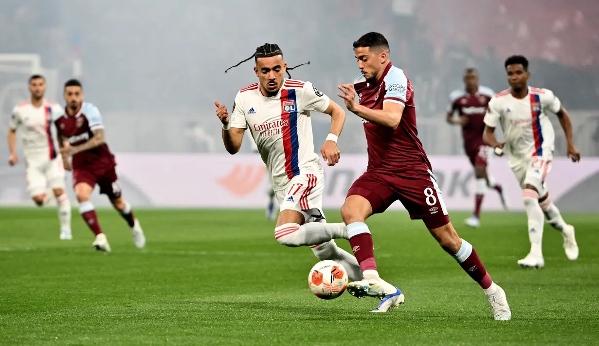 Gelandang West Ham United Pablo Fornals (kanan) berebut bola dengan bek Olympique Lyon Malo Gusto pada leg kedua perempat final Liga Europa melawan Lyon di Parc Olympique Lyonnais, Jumat (15/4/2022) dini hari WIB. West Ham lolos ke semifinal usai melibas tuan rumah Lyon 0-3. (Jeff PACHOUD/AFP)