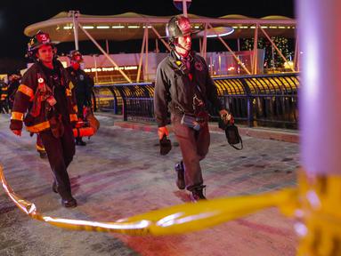 Petugas membawa jenazah korban jatuhnya helikopter di East River di New York City, AS (11/3). Akibat insiden ini, satu korban selamat dan dua korban tewas. (Eduardo Munoz Alvarez/Getty Images North America/AFP)