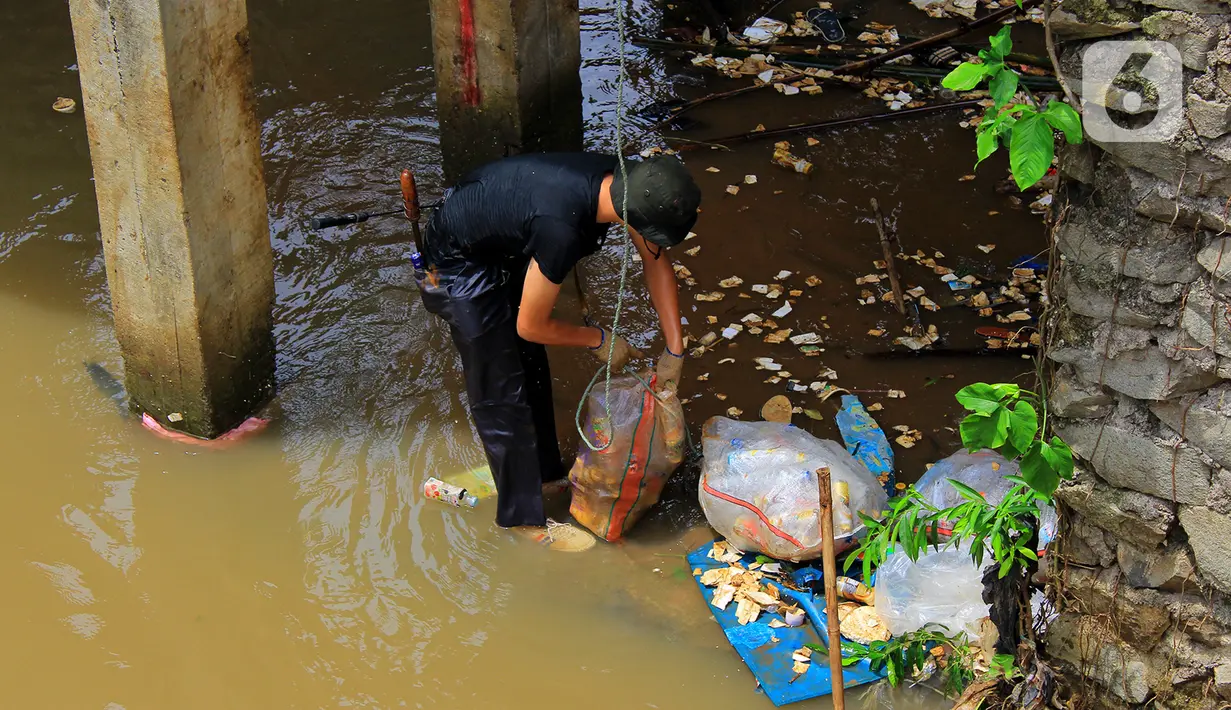Warga kerja bakti membersihkan sampah yang terbawa aliran Kali Baru di bawah Jembatan Merah, Jalan Pitara Raya, Depok, Jawa Barat, Rabu (19/2/2020). Pascahujan deras yang terjadi sehari sebelumnya, sampah dari arah Bogor terbawa aliran Kali Baru hingga ke Depok. (merdeka.com/Magang/Muhammad Fayyadh)