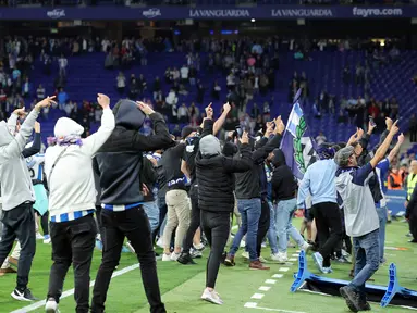 Suporter Espanyol bereaksi menyerbu lapangan atas kemenangan Barcelona setelah laga tandang pekan ke-34 La Liga 2022/2023 di RCDE Stadium, Senin (15/5/2023) dini hari WIB. (Photo by Lluis GENE / AFP)