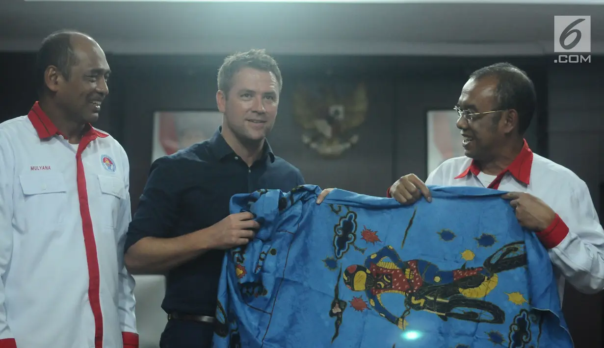 Mantan pemain tim nasional Inggris, Michael Owen (tengah) menerima suvenir batik dari Sesmenpora, Gatot S Dewa Broto (kanan) usai pertemuan di kantor Kemenpora, Jakarta, Senin (5/2). Pertemuan berlangsung terbuka. (Liputan6.com/Helmi Fithriansyah)