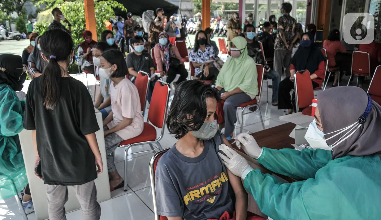 Petugas menyuntikkan vaksin Covid-19 kepada anak dalam program Vaksinasi Keliling di RPTRA Pulo Besar, Sunter Jaya, Jakarta, Selasa (12/7/2021). Kementerian Kesehatan mengalokasi 20 juta dosis vaksin Covid-19 untuk anak usia 12-17 tahun yang diberikan secara bertahap (merdeka.com/Iqbal S Nugroho