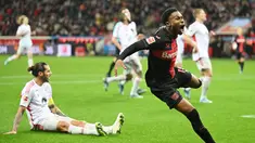 Pemain Bayer Leverkusen, Nathan Tella, melakukan selebrasi setelah mencetak gol ke gawang Union Berlin pada laga Bundesliga di Bay Arena, Minggu (12/11/2023). Leverkusen tampil beringas dengan menang empat gol tanpa balas atas Union Berlin. (AFP/Ina Fassbender)