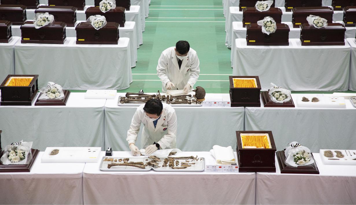 Anggota MND Agency for KIA Recovery and Identification (MAKRI) Korea Selatan menata jenazah tentara China yang tewas dalam Perang Korea di Incheon, Korea Selatan, Rabu (1/9/2021). Korea Selatan memulangkan 109 tentara China yang tewas dalam Perang Korea. (Jeon Heon-kyun/Pool Photo via AP)