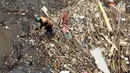 Petugas kebersihan Pemprov DKI Jakarta mencoba mengurai sampah yang terbawa arus di Pintu air Manggarai, Jakarta, Senin (2/10). Pembersihan itu dilakukan untuk melancarkan aliran Sungai Ciliwung yang melewati Pintu Air Manggarai (Liputan6.com/Johan Tallo)