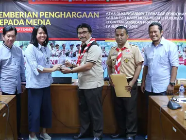 Ketua Kwarnas Gerakan Pramuka Adhyaksa Dault menyerahkan plakat kepada Redaktur Eksekutif Liputan6.com Irna Gustiawati di Gedung Kwarnas Gerakan Pramuka, Gambir, Jakarta Pusat, Senin (24/9). (Liputan6.com/Immanuel Antonius)