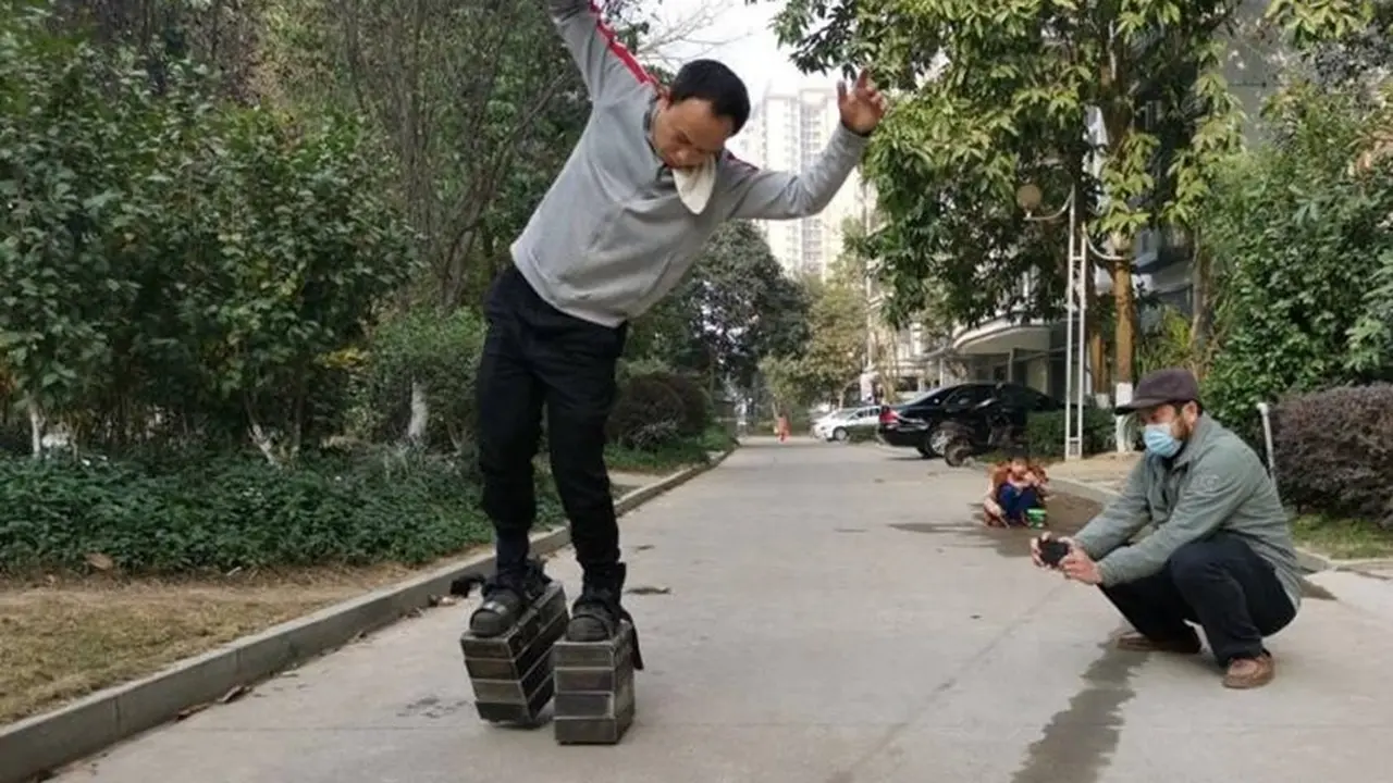 Seorang pria berkepala 5 berjalan pakai sepatu berpelat baja seberat 150 kg.