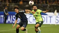 Pemain Australia, Aziz Behich (kanan) berduel dengan pemain Jepang, Yu Hirakawa, pada laga lanjutan Grup C Kualifikasi Piala Dunia 2026, di Optus Stadium, Perth, Kamis (5/6/2025). Behich menjadi pahlawan kemenangan Australia berkat gol tunggalnya di menit ke-91. (AFP / Colin Murty)